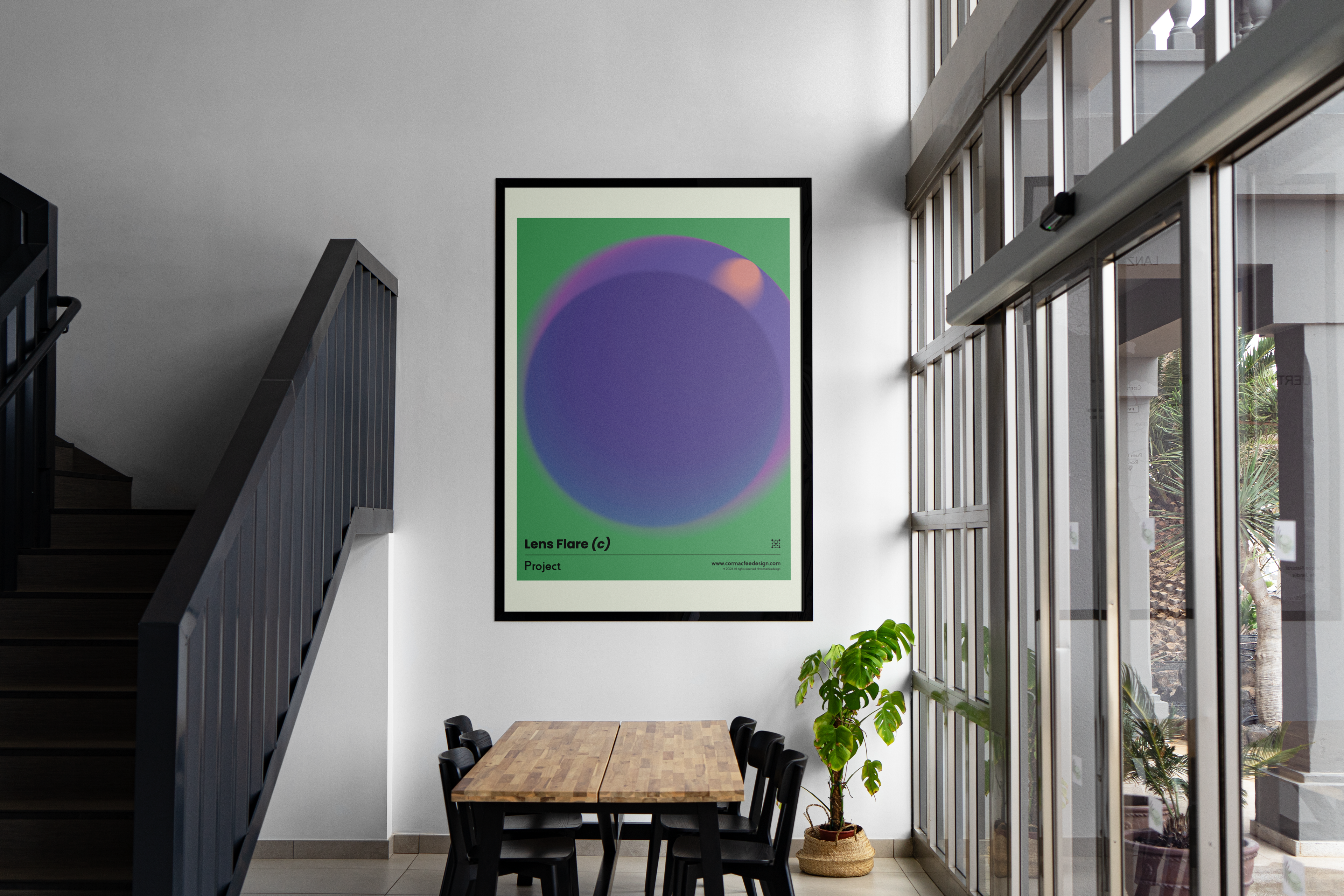 Framed abstract art print on a wall in a modern interior setting with a table and chairs.