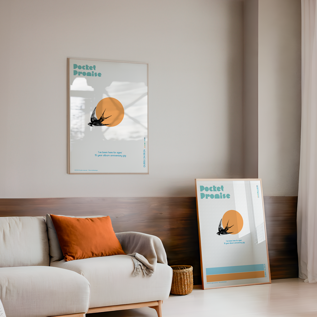 Living room with a sofa, cushions, and two framed posters on the wall.