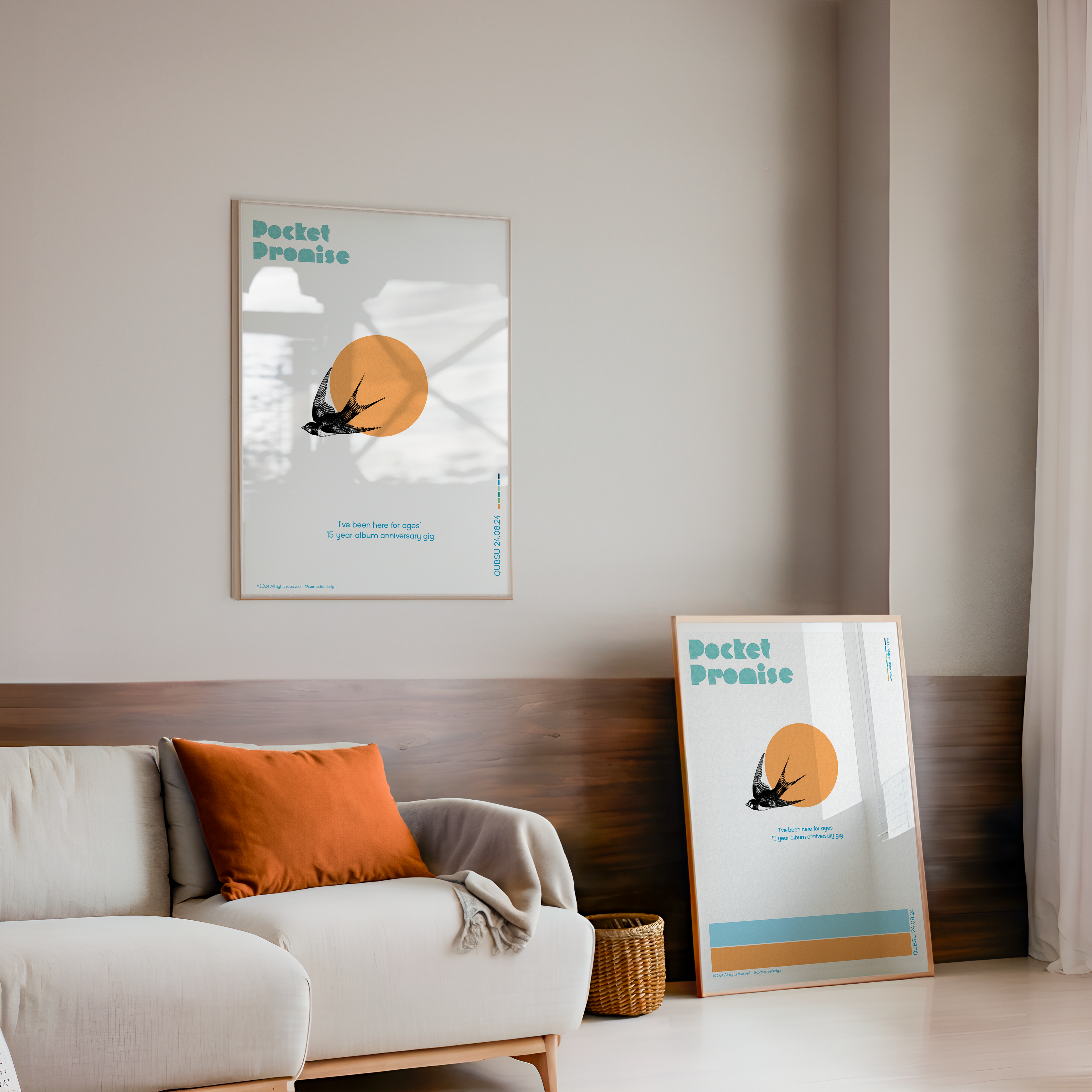 Living room with a sofa, cushions, and two framed posters on the wall.